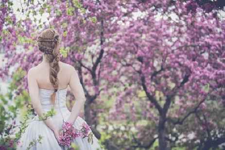 Bride outside with purple flower tree